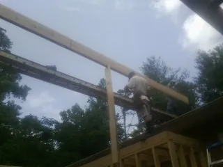 Carpenter setting a ridge beam over a new addition frame — Ice Dam Removal by Roofing Brothers in Emmitsburg